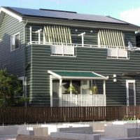 グリーンの壁と白いサッシが印象的な太陽光の住まい