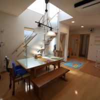 ガラス手摺のデザイン階段とオープンキッチンのシャープなデザイン住宅